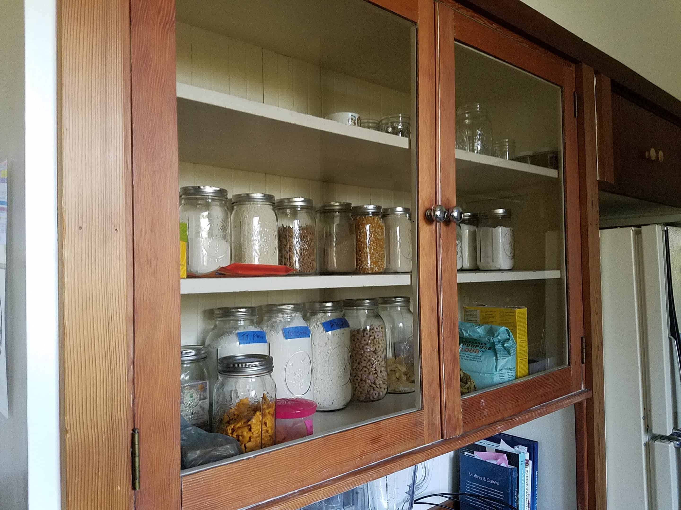 minimalist kitchen cabinet with dry goods in mason jars