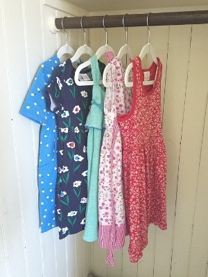 five dresses hanging in minimalist kids closet