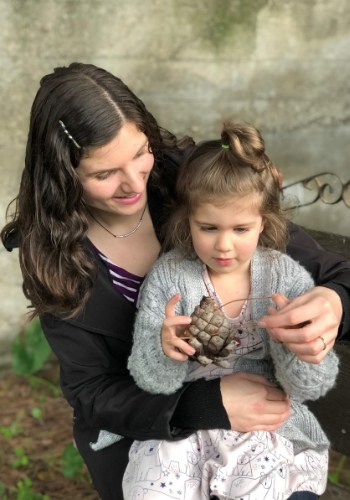 mom and daughter looking at pinecone